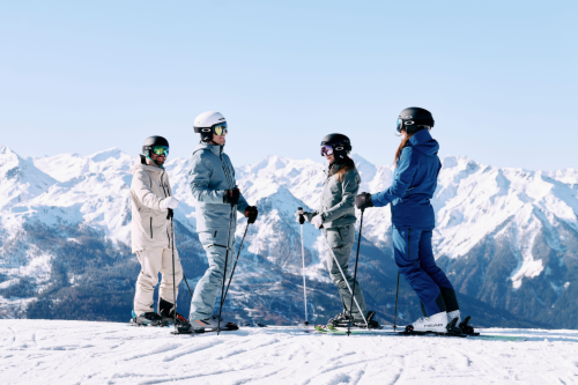 Two skiers walking in the snow, carrying their skis over their shoulders