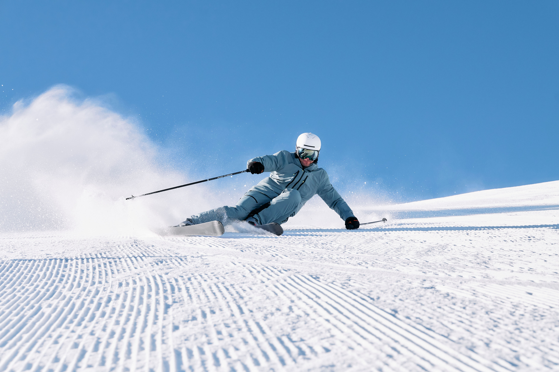 Skier racing down the slope, leaving a cloud of snow behind