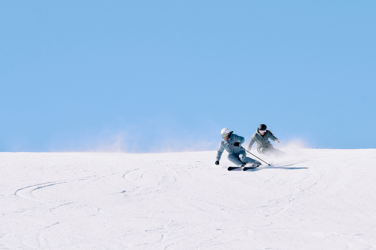 Zwei Skifahrer fahren die Piste hinunter