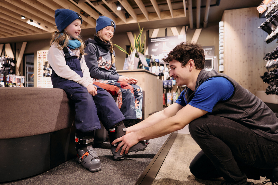 Employee helps a child put on ski boots