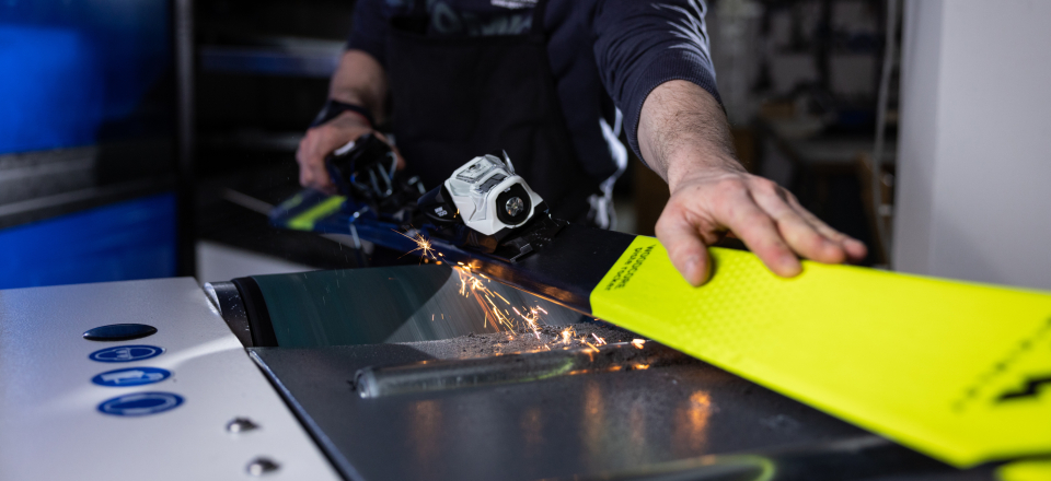 Nahaufnahme wie die Kanten eines gelben Skis geschliffen werden