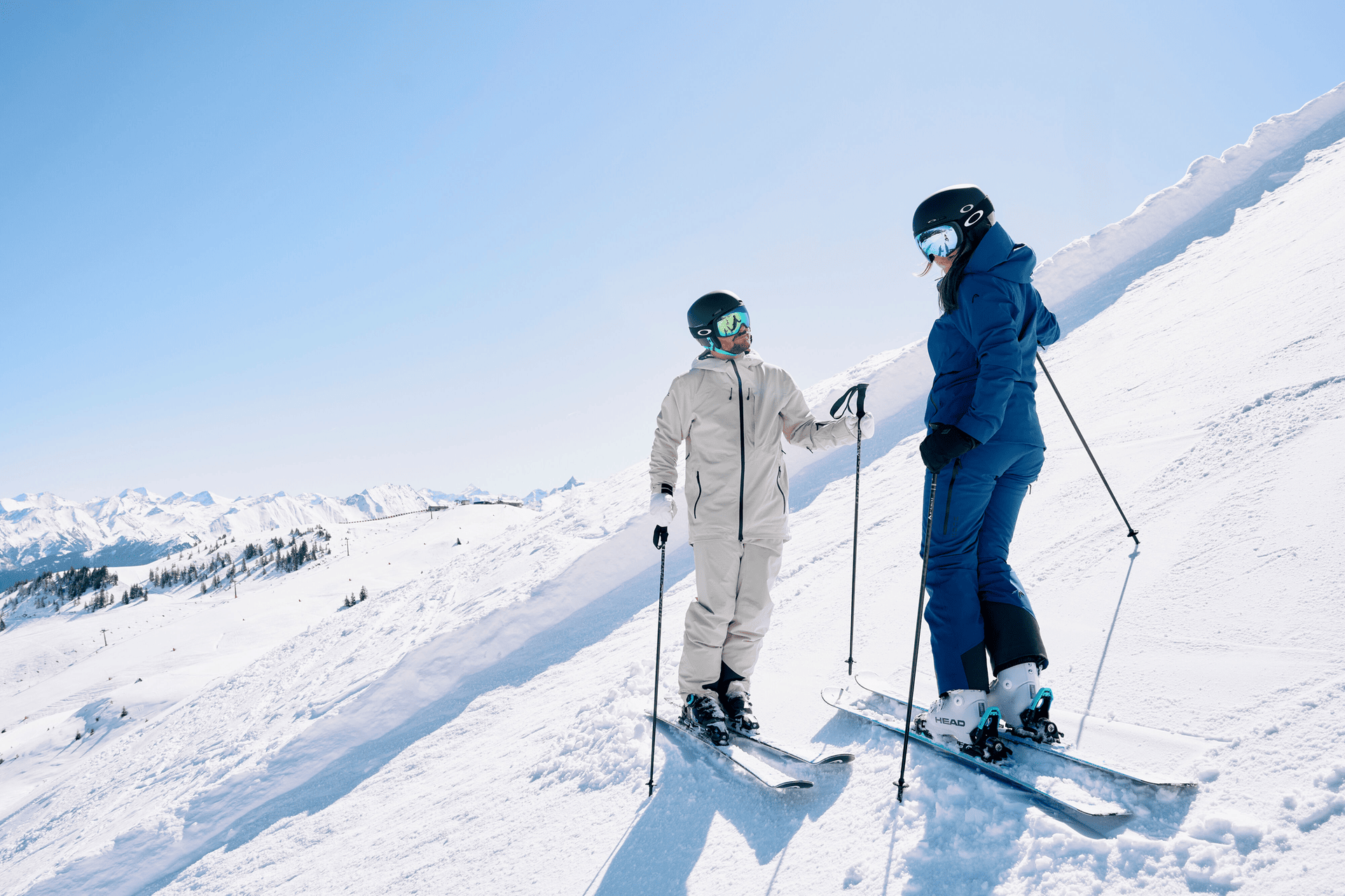 Two skiers standing on the slope, looking at each other